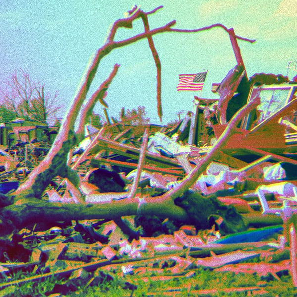 A destroyed home with an American flag still standing.