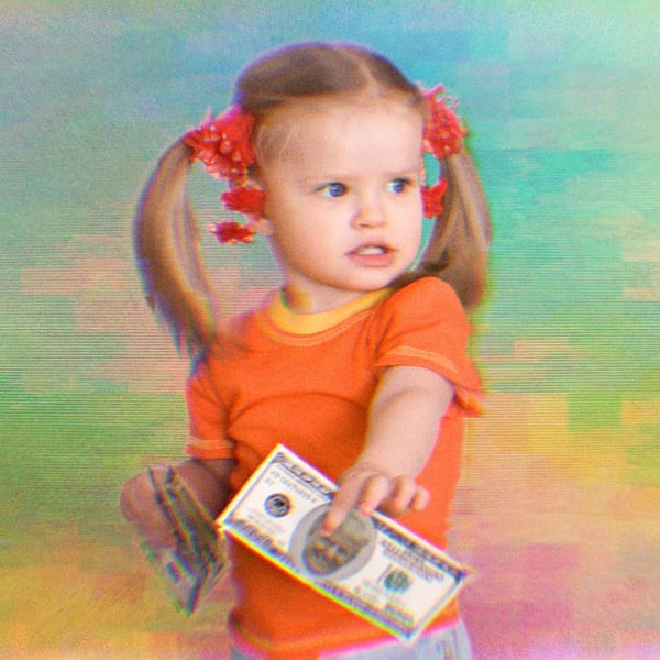 A little girl holding a $100 bill with Trump's face on it.