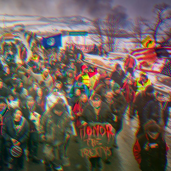 Water Protectors protesting the Dakota Access Pipeline in 2017. A man is holding a sign that says, “Honor The Treatys,” another says, “Water Is Life.”