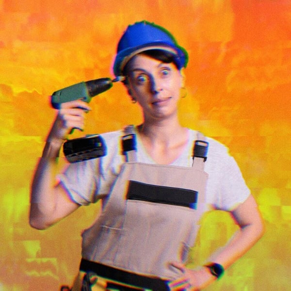 A woman holding a drill to her temple looking exasperated.