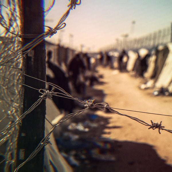 Barbed wire surrounding an encampment at the border