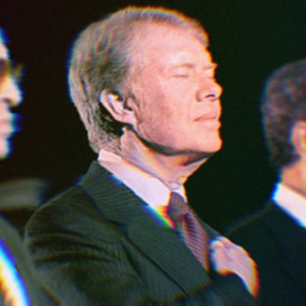 Begin, Carter, and Sadat at a ceremony in September, 1978. Carter is in focus and has his hand over his heart with his eyes closed.
