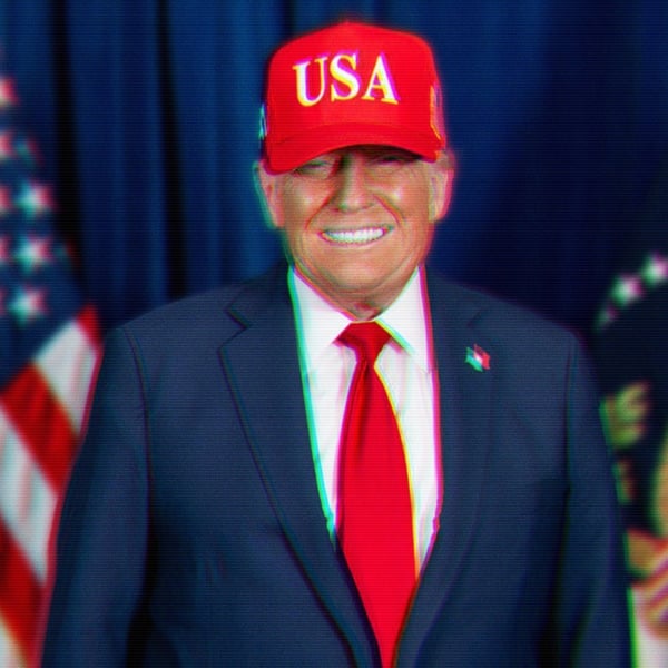 Donald Trump smiling evily wearing a red hat with USA in white letters