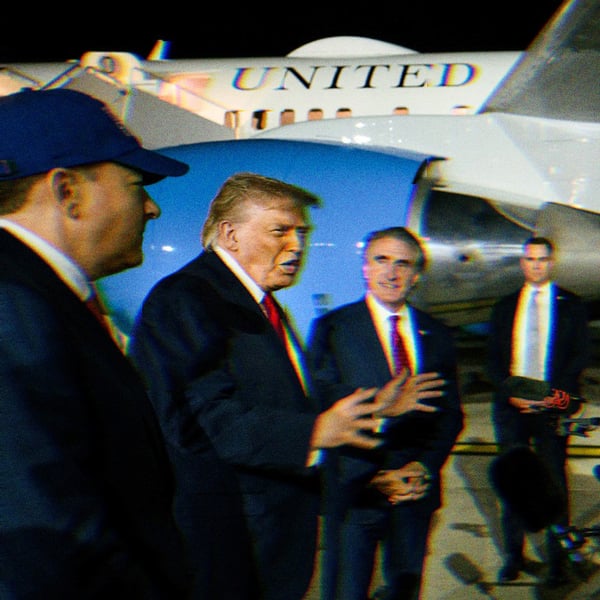 Trump talking to reporters before he boards Air Force One, visible in the background.