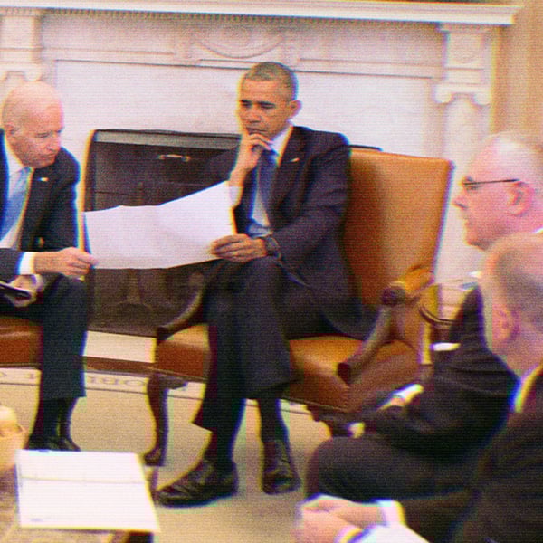 President Barack Obama and Vice President Joe Biden receive the Presidential Daily Briefing in the Oval Office, April 13, 2016. Unnamed staffers surround them.