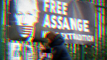 Glitchy photo of a banner with a photo of Julian Assange with American flag tape over his mouth. Banner text says, 
