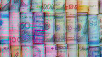 Rolled up bills from different international currency. Image has a rainbow, streaky filter overlayed. 