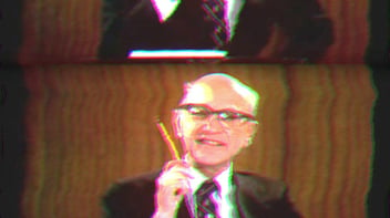 Milton Friedman holding a pencil. 