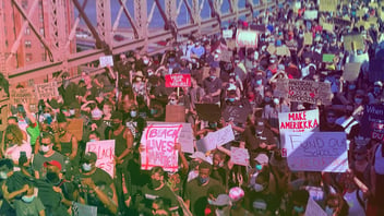 A large Black Lives Matter protest; visible signs say 'Black Lives Matter,' 'Fund Our Schools' and 'American Democracy Is a Hypocrisy.'