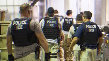 A group of ICE men investigating a workplace.