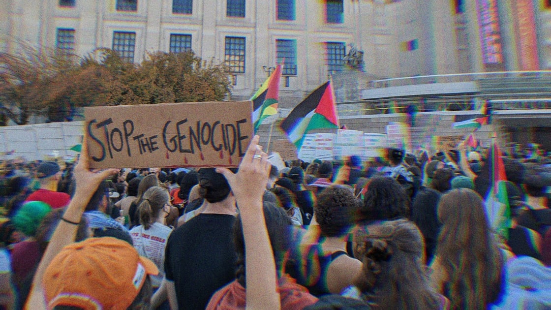 A person holds up a Stop the Genocide sign at a pro-Palestine rally in 2023.