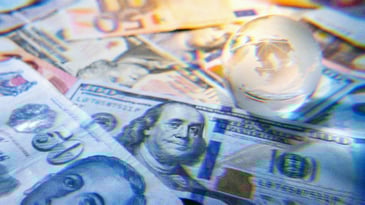 Crystal globe on top of currency from around the world.