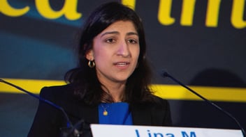 Lina Khan speaking at a podium.