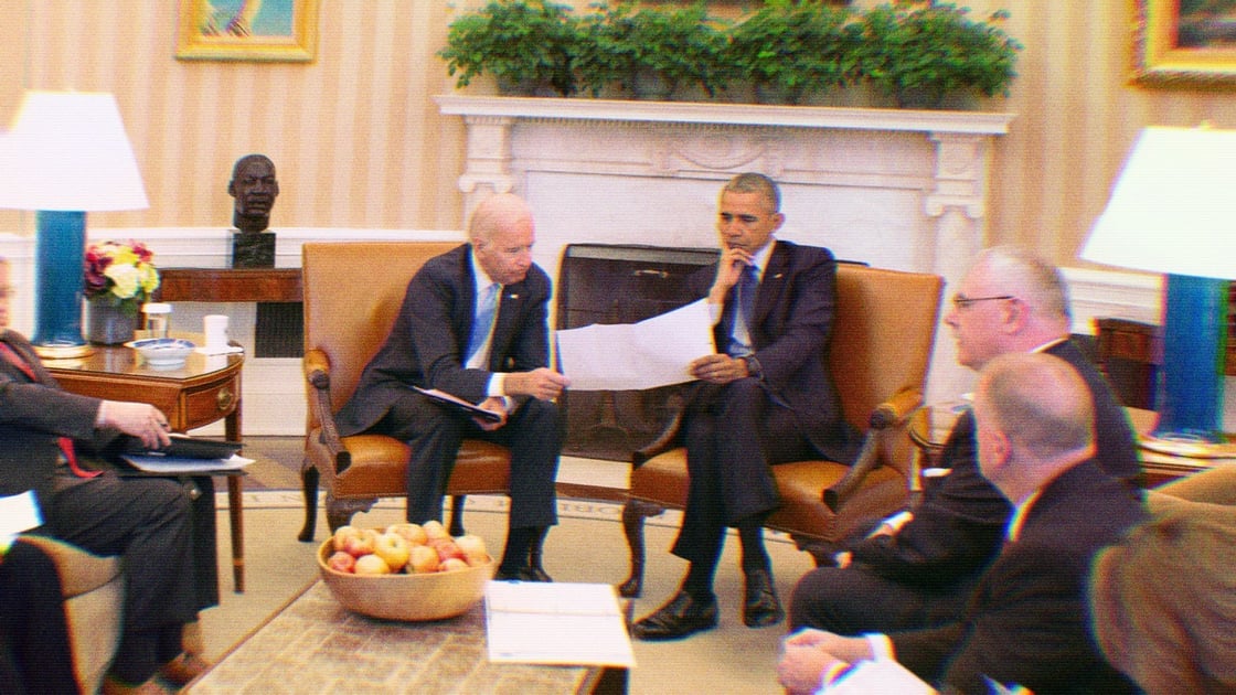 President Barack Obama and Vice President Joe Biden receive the Presidential Daily Briefing in the Oval Office, April 13, 2016. Unnamed staffers surround them.