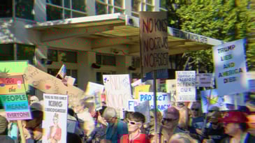 Protestors in California at No Kings, holding signs that read ‘We the people means everyone,’ 'No Kings, No Crowns, No Fascist,’ ‘Trump Lies and America Dies,’ and more out of view.