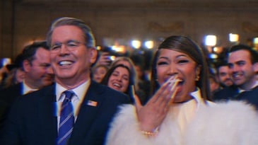 Scott Bessent sitting next to Nicki Minaj. The pair are laughing.