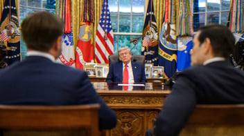 Trump sitting at his desk in the Oval Office, he looks sleepy. Across from him are JD Vance and Marco Rubio; they are out of focus and only their backs are visible.