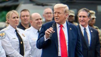 Trump visits law enforcement and members of the National Guard at the U. S. Park Police Anacostia Operations Facility. He stands holding a microphone, speaking to a crowd.