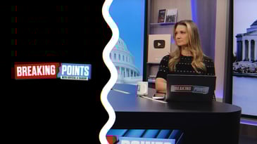 The Breaking Points with Krystal and Saagar logo alongside a photo of Krystal Ball on the Breaking Points set. She sits in front of her laptop and looks to her cohost who is not pictured.