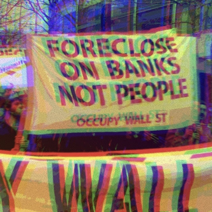 Protestors holding Occupy Wall Street sign that says,