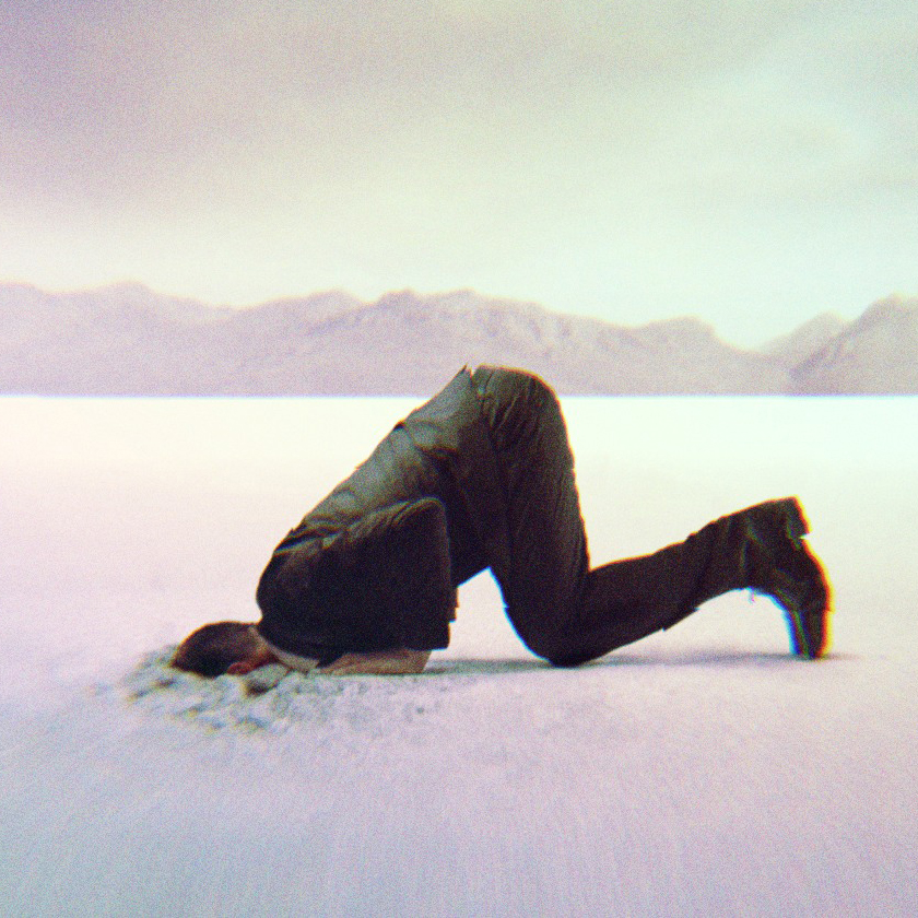 A man putting his head in the sand.