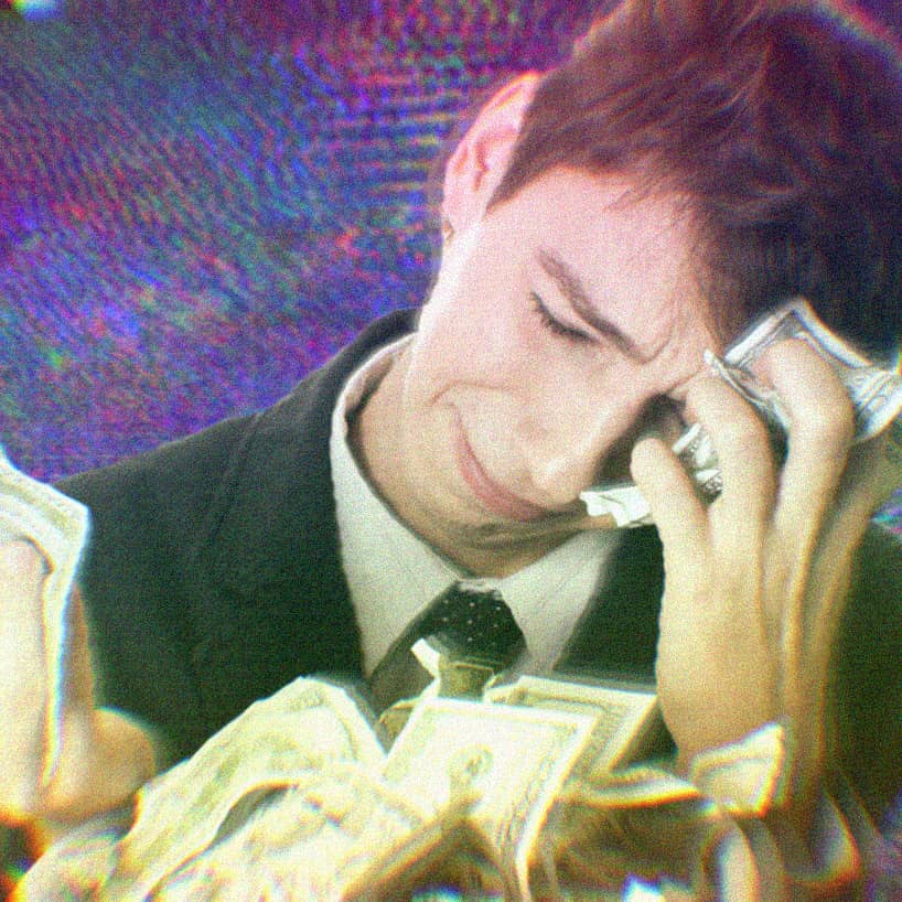 Young white male tech worker wiping tears from his face with bundles of cash