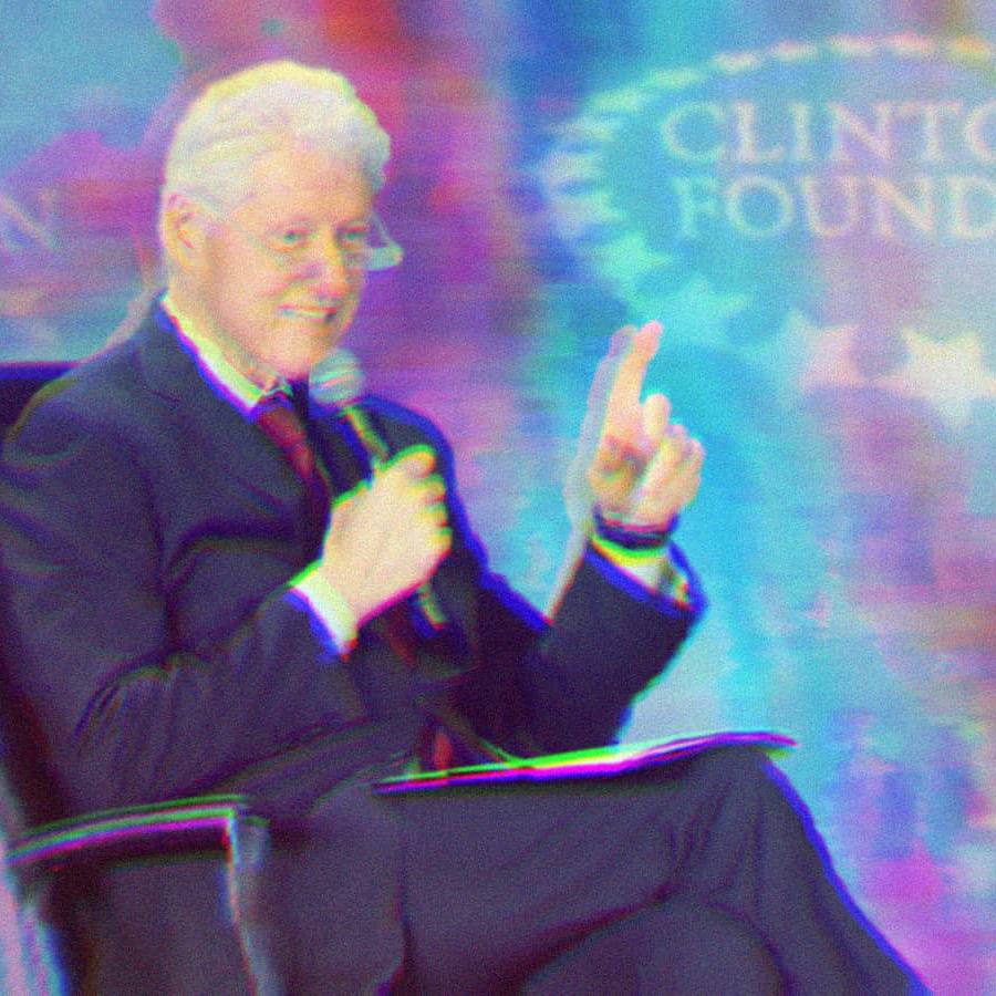 Bill Clinton sitting in a chair, pointing and holding a microphone. A Clinton Foundation banner sits in the background