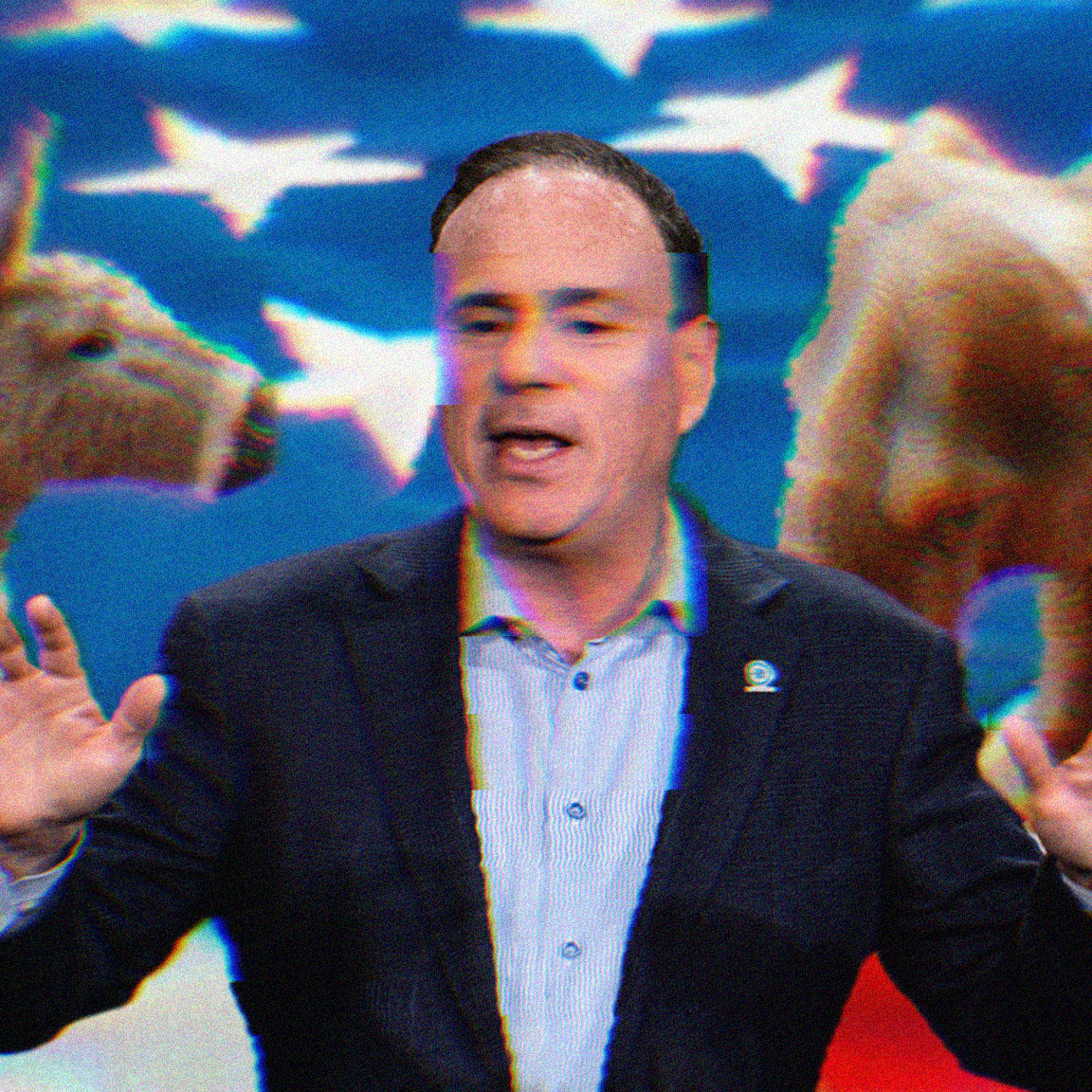 Jay Jacobs standing mid-speech; the background is an American flag and an elephant and a donkey.