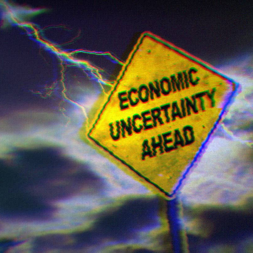 Lightning hitting a yellow road sign that says 'economic uncertainty ahead.'