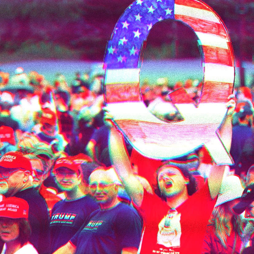 Man wearing QAnon shirt holding a Q sign decorated like the American Flag