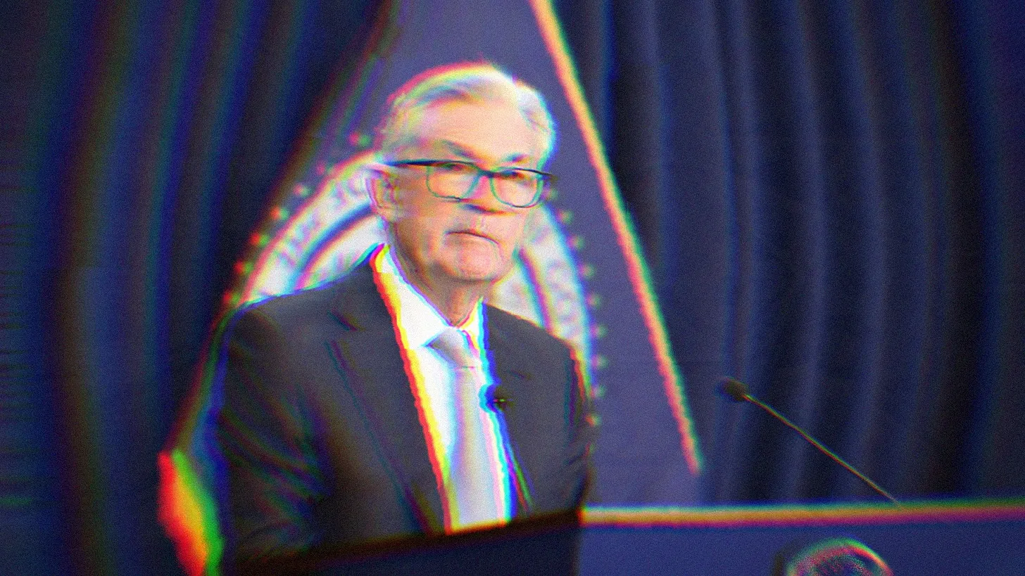 Jerome Powell standing at a podium during a press conference.