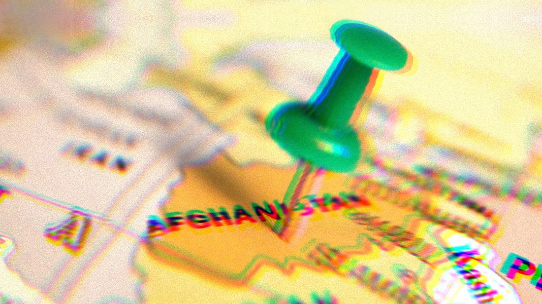 Green pushpin pressed into a map, with the pin sticking into Afghanistan. 