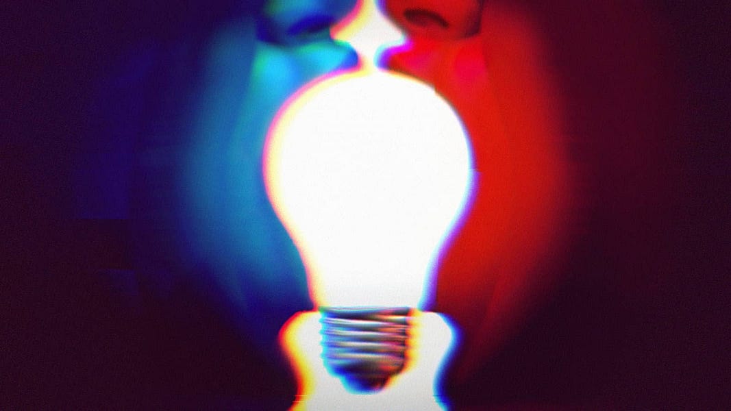 A Blue face and a Red face turned towards each other, with their mouths open. Each person is holding the side of a lightbulb in their mouth. Bipartisan concept. 
