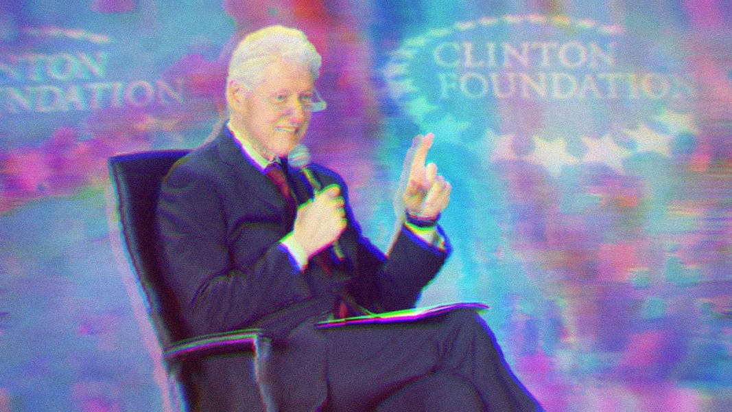 Bill Clinton sitting in a chair, pointing, and holding a microphone. A Clinton Foundation banner sits in the background.
