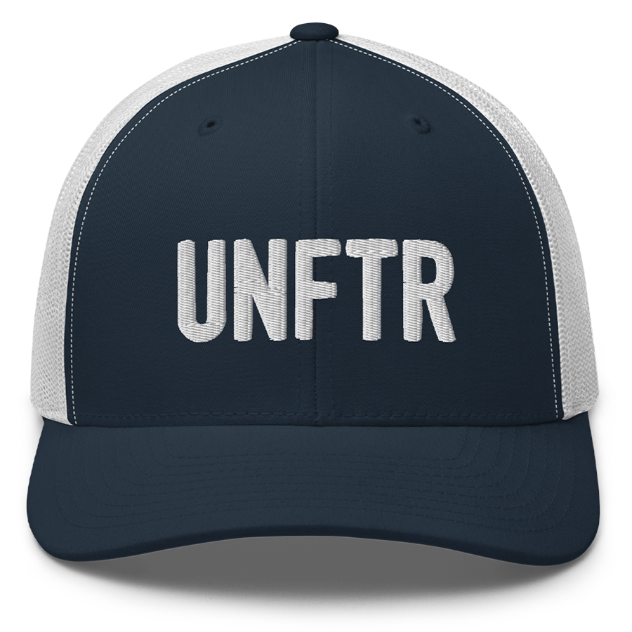Navy trucker hat with white panels and white embroidery that says UNFTR