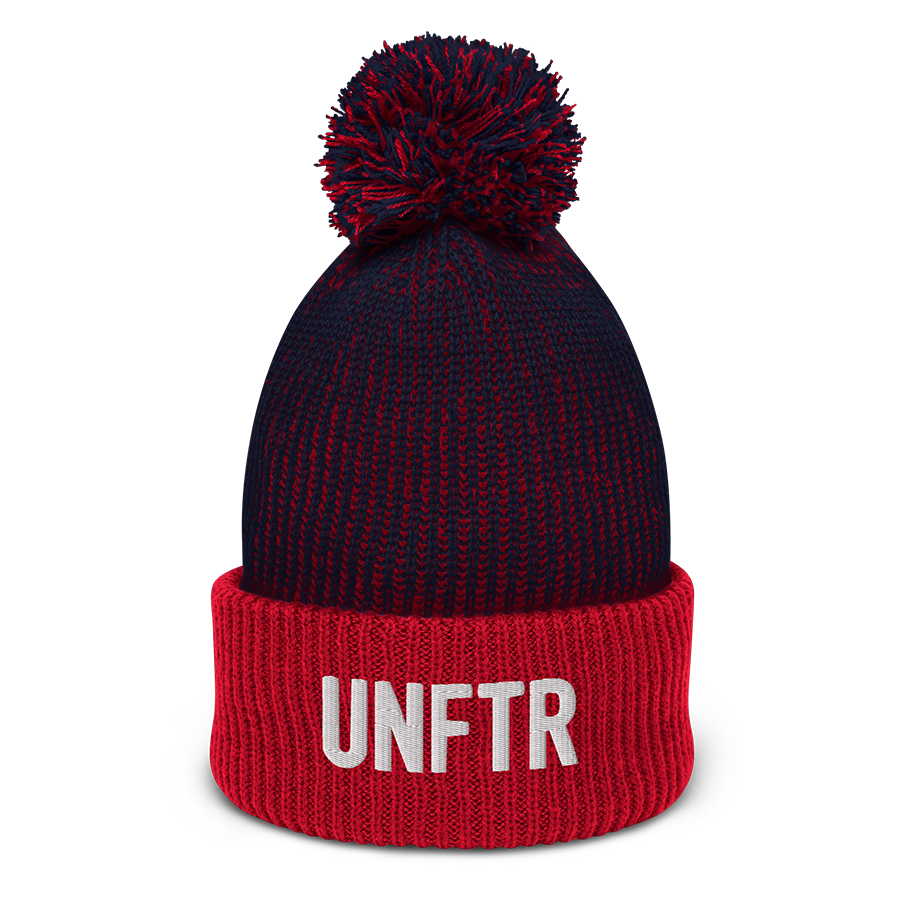 Speckled navy and red pom-pom beanie with white embroidered logo that says ‘UNFTR’