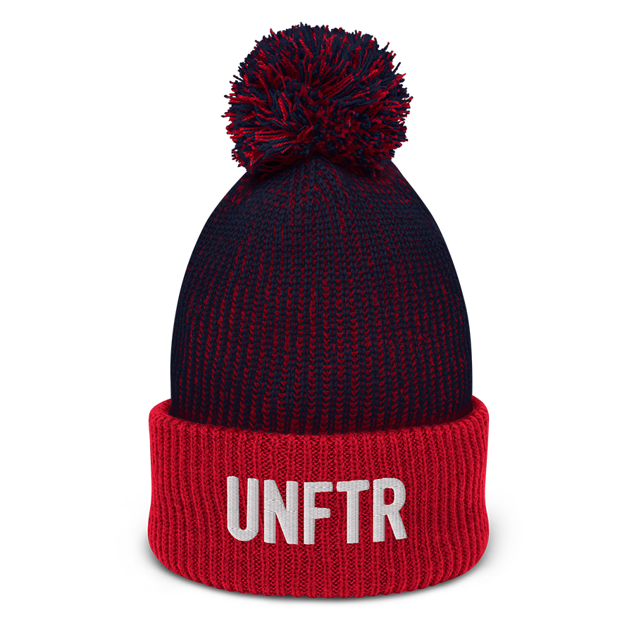 Speckled navy and red pom-pom beanie with white embroidered logo that says ‘UNFTR’