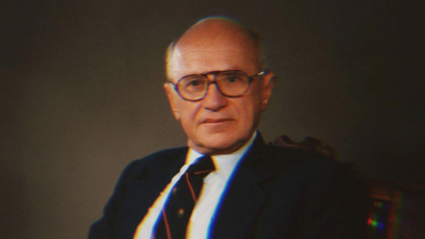 A portrait of Milton Friedman. He wears thick, round glasses, a blue suit jacket and red and black striped tie.