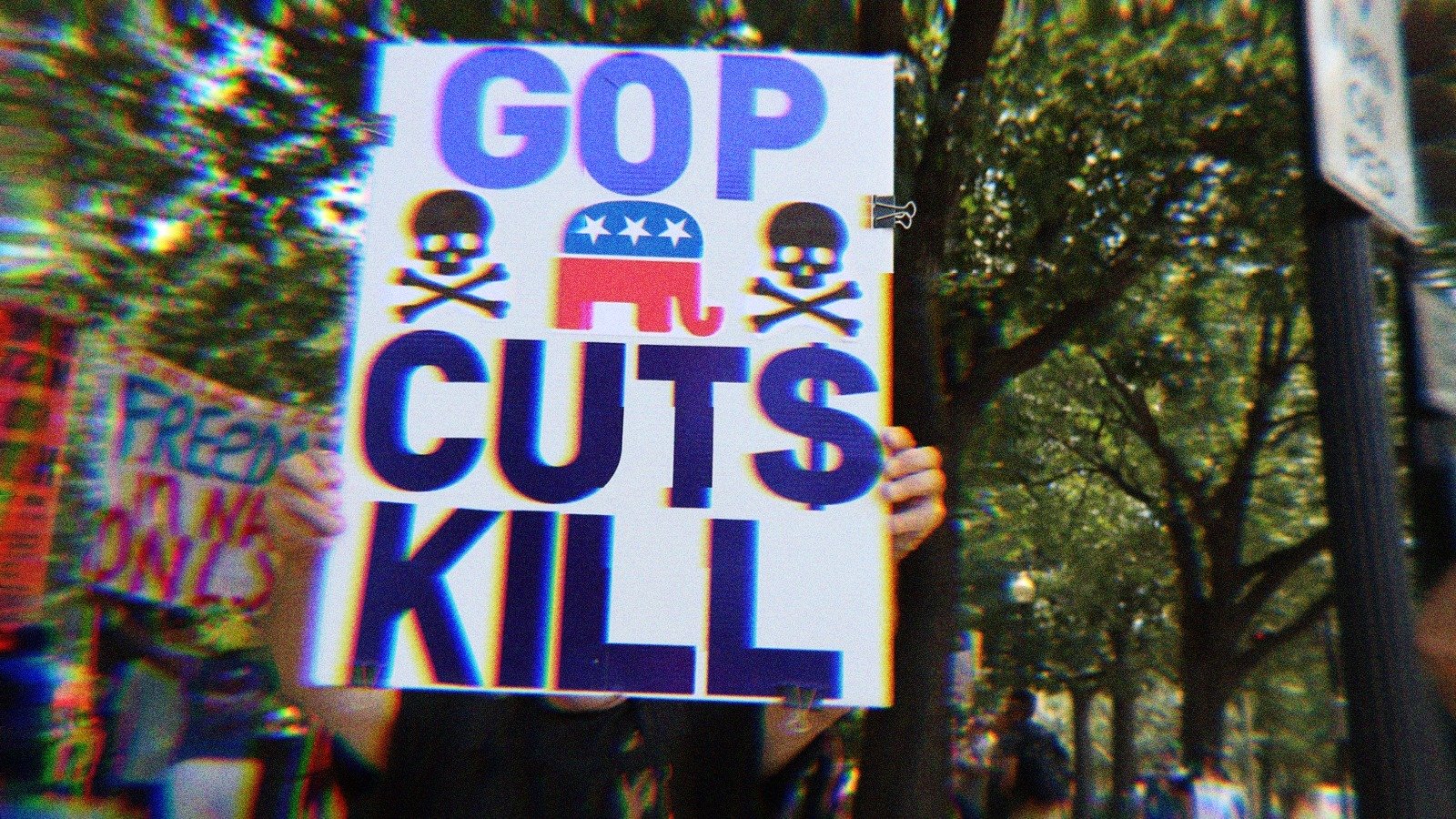 A protest sign that says ‘GOP Cuts Kill’ with skulls.