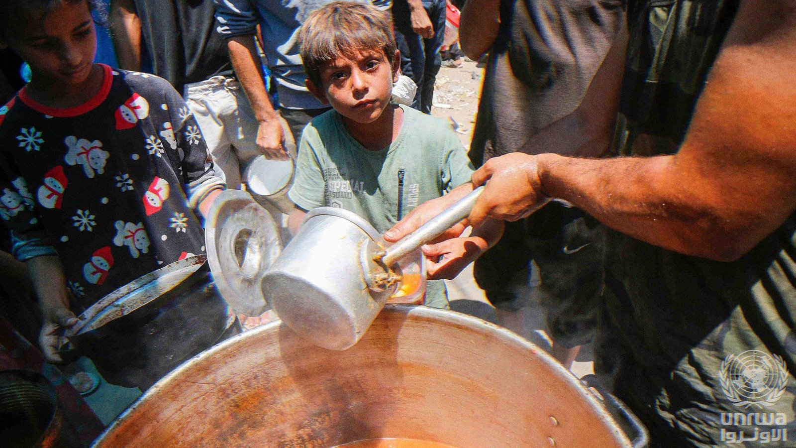Displaced Palestinians gather to receive food from a charity in Deir el-Balah, Gaza Strip.