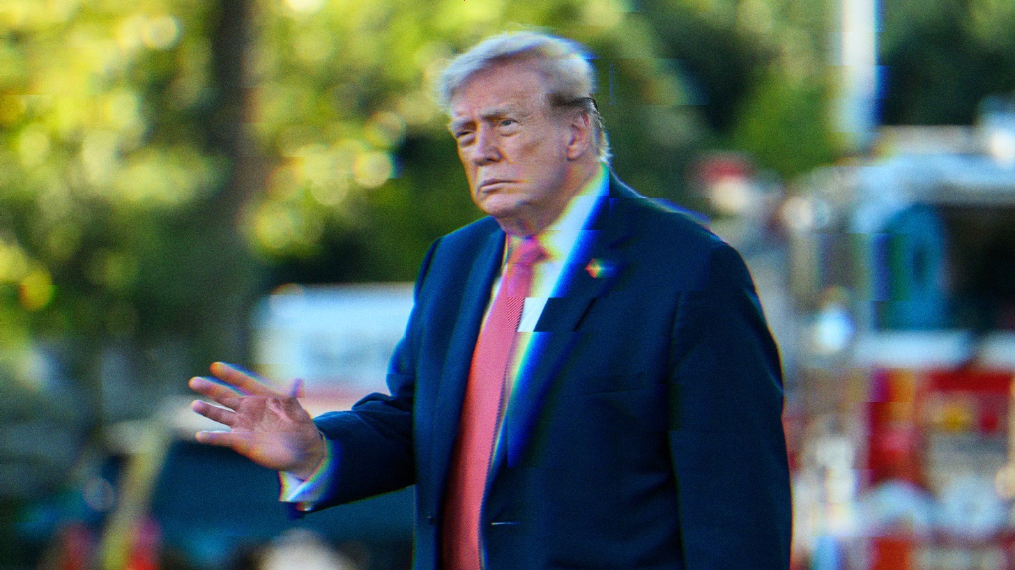 Donald Trump walking, and slightly waving. He is not smiling.