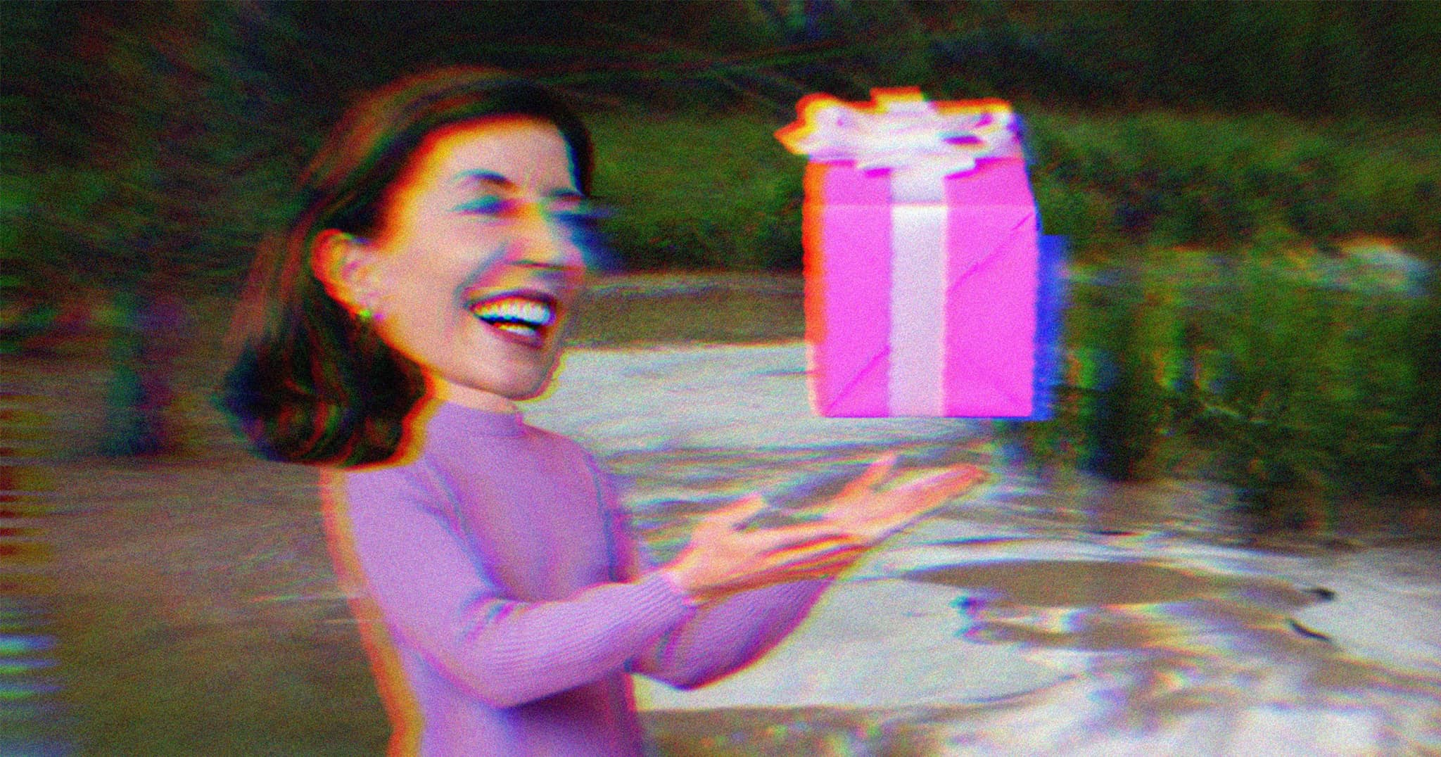 Kathy Hochul laughing and giving a gift. The background is a mudboil in the Tully Valley.