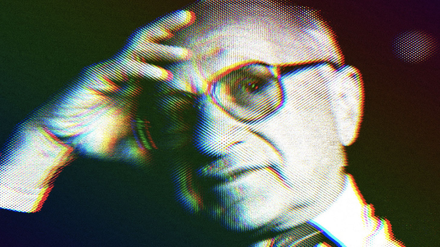 Milton Friedman wearing his signature glasses with his hand resting on his forehead.