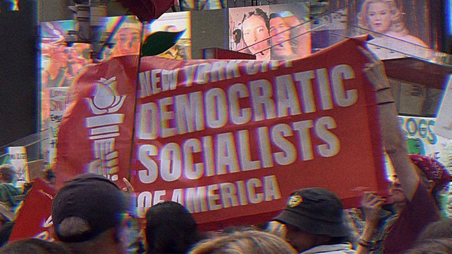 Rally in Times Square, NYC. Individuals are holding up a red banner that reads ‘New York City Democratic Socialists of America.’