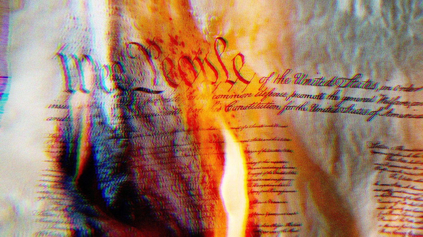 The U.S. Constitution on fire, the words We The People are burning.